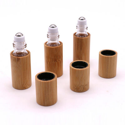 petit pain en bambou de bouteille de l'huile 15ml essentielle sur le verre à bouteilles avec le chapeau en bambou naturel