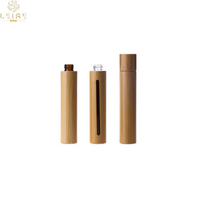 Bouteille cosmétique naturelle en verre d'huile essentielle avec le vrai rouleau en bambou en métal de chapeau